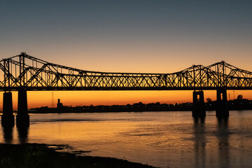 Fototapeta na wymiar Sunset on the Mississippi River in Natchez, Mississippi with the Natchez Vidalia Bridge.