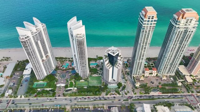 Sunny Isles Beach city with luxurious highrise hotels and condo buildings and busy ocean drive on Atlantic coast. American tourism infrastructure in southern Florida
