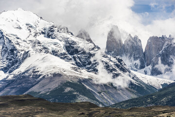 Torres del Paine peaks coming from clouds - 586340377