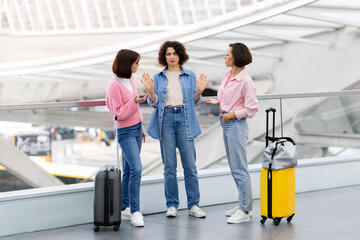 Fototapeta na wymiar Three Female Friends Arguing While Waiting At Airport Terminal