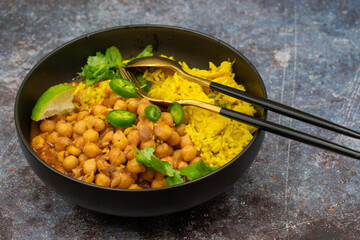 Curried chickpea and rice bowl on plain background, copy space