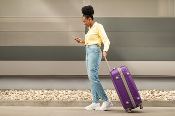 African American Traveler Lady Using Travel App On Smartphone Outside