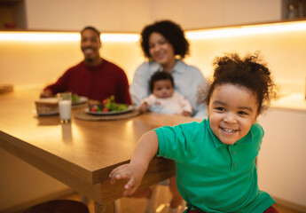 Cute black boy preschooler enjoying time with parents and sibling