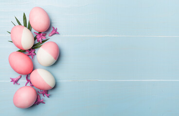 Pink Easter eggs with decor on wooden background, top view