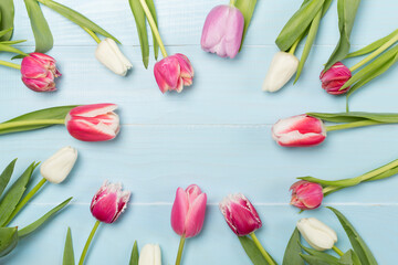 Bright tulips on wooden background, top view