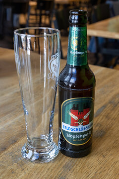 KLOSTERS, SWITZERLAND - MARCH 02, 2023:  Bottle of Feldschl&ouml;sschen Hopfenperle beer on a table with glass