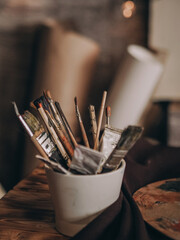 many artist brushes and tubes of paint