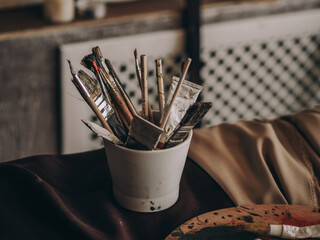 many artist brushes and tubes of paint