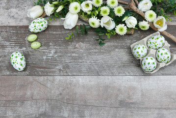 Osterhintergrund: Ostereier mit Blumen auf altem Holz  mit Platz für Text.	