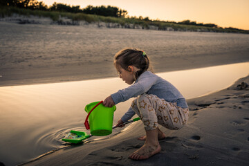 Girl having amazing time playing at Baltic Sea after sunset, Poland