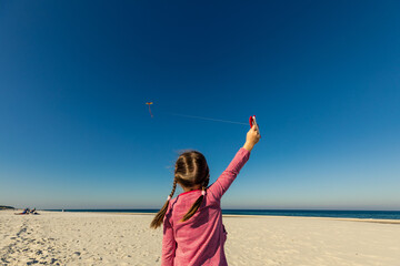 Girl flying kite at Baltic Sea, Poland