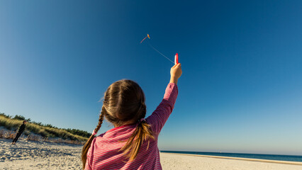 Girl flying kite at Baltic Sea, Poland