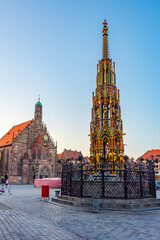 Schöner Brunnen and Frauenkirche in German town Nürnberg during sunrise