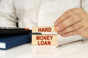 In the hands of a businessman, wooden blocks with the inscription - Hard money loan