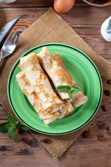 Sweet pancake with cottage cheese and raisins on wooden table. Pancakes with cheese. Shrovetide.