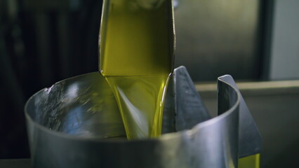 Olive oil machine working at factory closeup. Fresh product pouring in tank bin