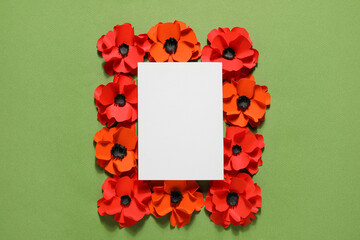 Blank paper sheet with poppy flowers on green background