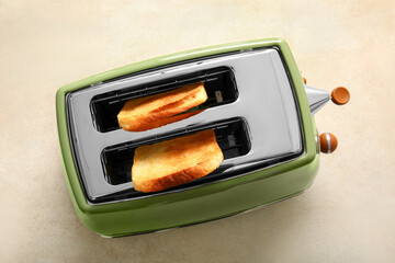 Modern toaster with crispy bread slices on beige background