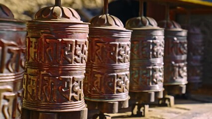 Close-up of many Tibetan prayer wheels spinning in slow motion, Nepal