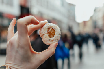 Hand holding a cookie on the street market