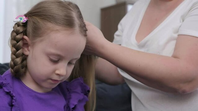 hairdresser stylist brushing child girl blond hair and styling hairdo braid hairstyle getting ready for scool or going out