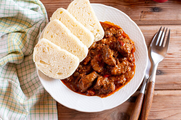 Traditional czech goulash with dumplings on table