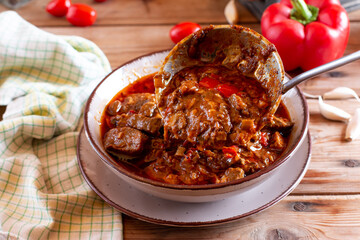 Traditional goulash soup with stew and paprika on the table. Bograch.