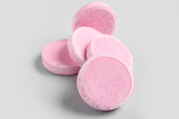 Obraz na płótnie Canvas Pink soluble tablets on grey background