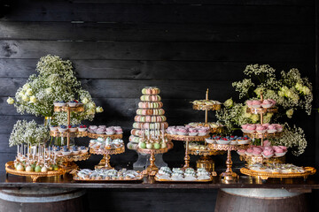 Delicious wedding reception candy bar Dessert table for a wedding outdoor party. Ombre cake,...