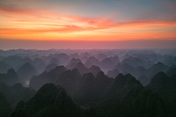 Obraz premium Aerial top view of fresh paddy rice, green agricultural fields with mountain hills valley in countryside or rural area of Ninh Binh, in Asia, Vietnam. Nature landscape background.