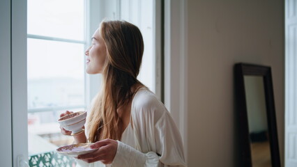 Tender woman drinking espresso at window interior portrait. Girl posing camera