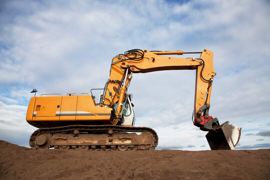 Gelber Kettenbaggger / Bagger mit Erdaushub