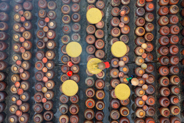 Workers working in heap of old ceramic or clay mud sauce pottery jars, vase or pots pattern texture background in garden. Terracotta. People lifestyle.