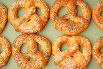 Tasty pretzels on green background, closeup