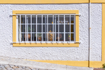 Barred window on a white stucco building.