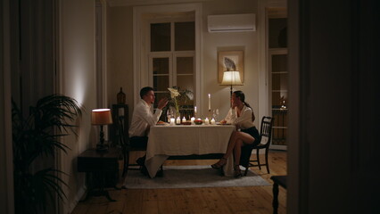 Fototapeta premium Loving couple romantic evening at home. Lovers enjoying dinner with candles