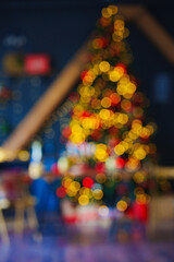 unfocused. a large Christmas tree decorated in a room with a black wall. blur