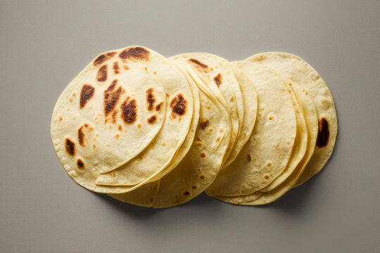 Stack of homemade wheat flour tortillas for making takos on grey table background. Mexican food concept.
