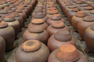 Heap of old ceramic or clay mud sauce pottery jars, vase or pots pattern texture background in garden. Terracotta