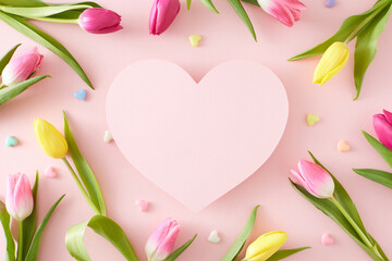 Mother's Day concept. Creative layout made of pink heart colorful tulips flowers and hearts baubles on isolated pastel pink background. Flat lay blank space.
