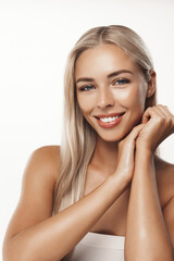 Skin care and women beauty. Girl with glowing healthy skin, touching her face and gazing at camera, standing with bare shoulders, perfect body without blemishes, white background