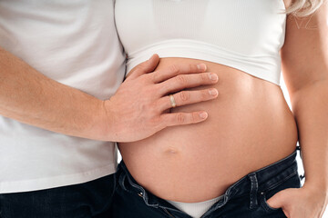 a man's hand on the stomach of a pregnant woman. 