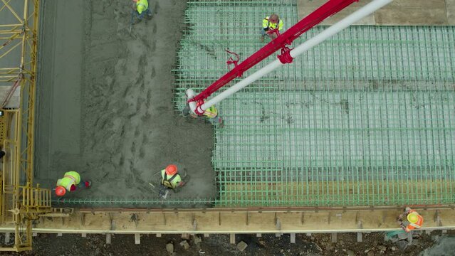 Aerial: Drone View Of Male Architect Spreading Concrete At Under Construction Site - Tuscaloosa, Alabama