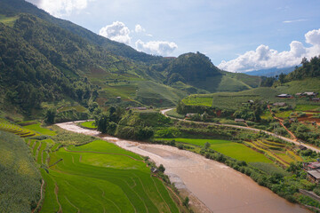 Naklejka premium Aerial top view of fresh paddy rice terraces, green agricultural fields in countryside or rural area of Mu Cang Chai, mountain hills valley in Asia, Vietnam. Nature landscape background.