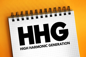 HHG - High Harmonic Generation acronym text on notepad, abbreviation concept background