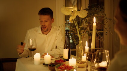 Gesturing guy chatting romantic dinner closeup. Sweethearts drinking wineglass 