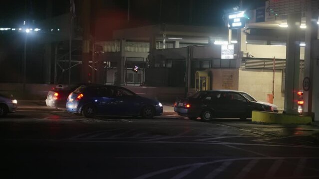Line of cars traveling for summer holidays stopped at customs vignette control at Greek border at night, slow motion