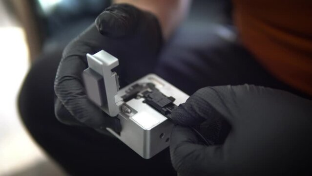 Fiber Optic Fusion Splicing Cable checking signal and Wire connection with Fiber Optic Fusion Splicing machine.The technician is checking the fiber optic cable