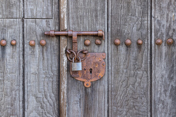 Rusted lock on a wooden door.