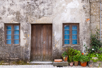 Wooden door and windows in an old stucco house.